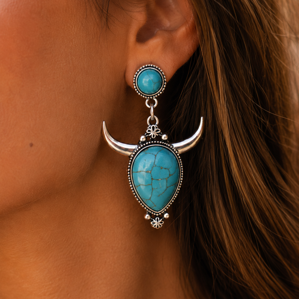 Turquoise and silver earrings worn by a person with brown hair.